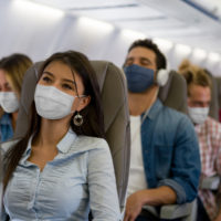 People on a plane with masks on.