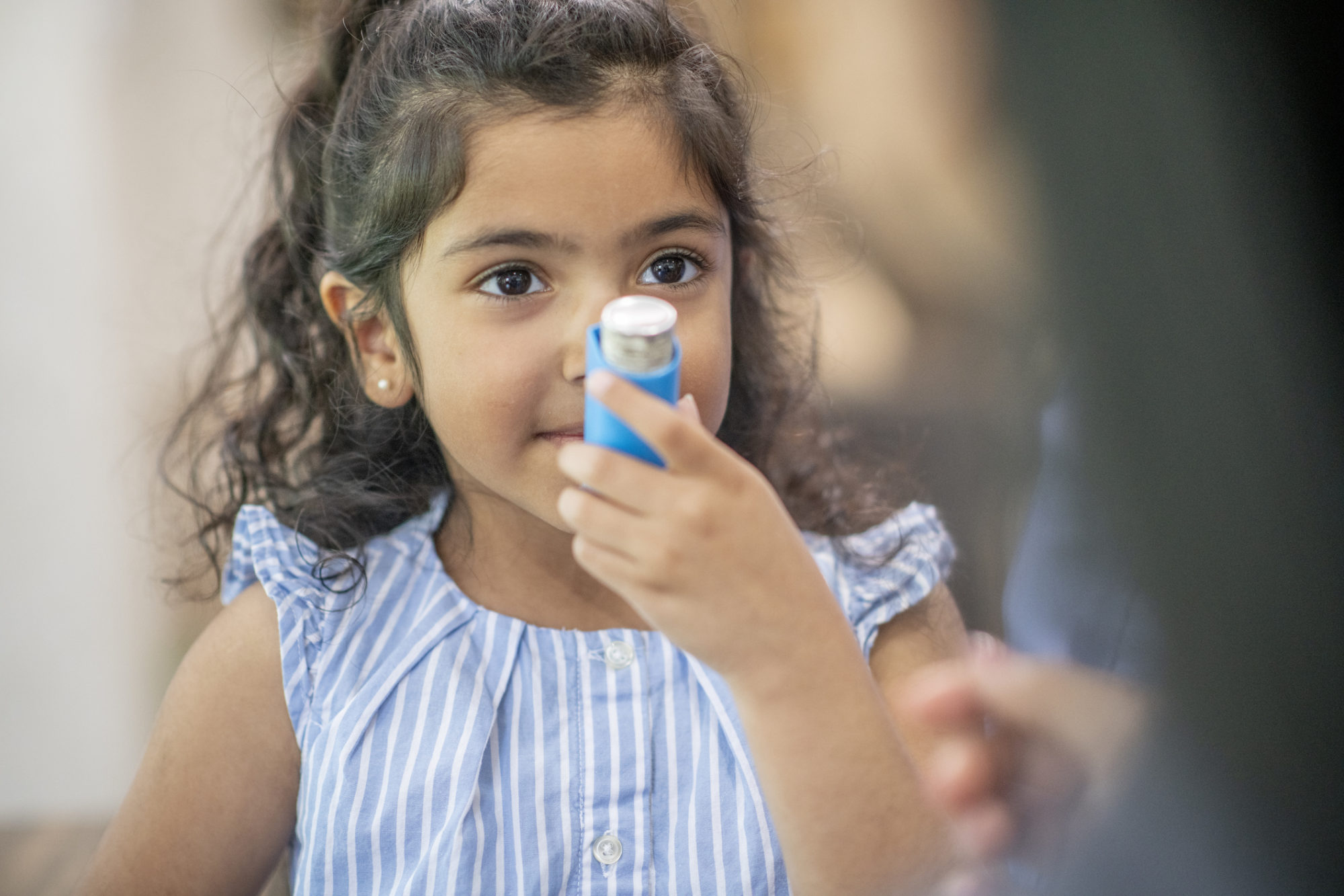 A girl using an inhaler