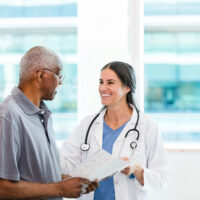 An older man speaking to a young doctor.